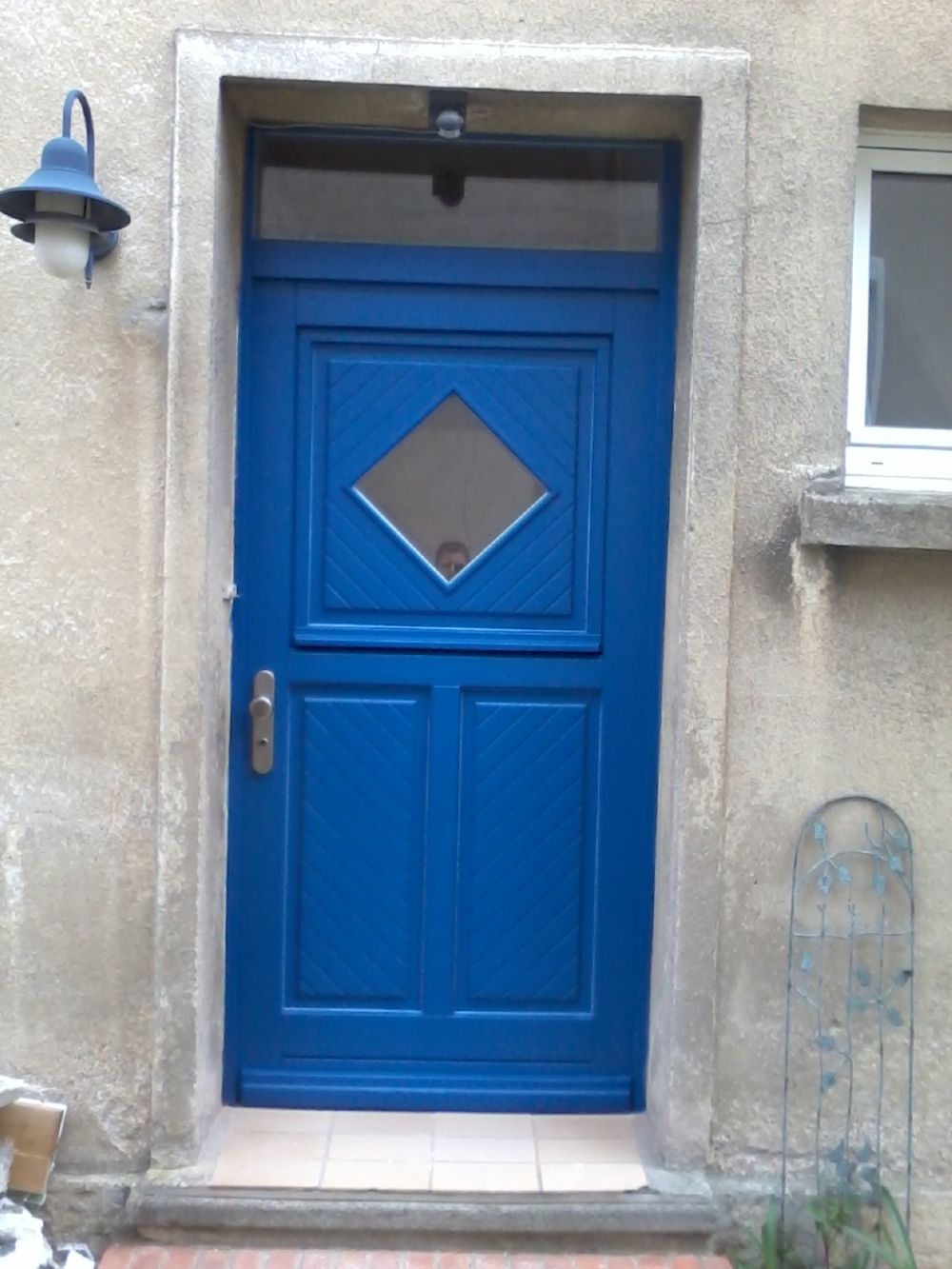 Blaue Haustür aus Holz in einem Altbauwohnhaus